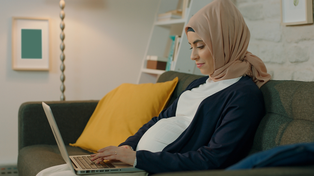 Pregnant person with laptop
