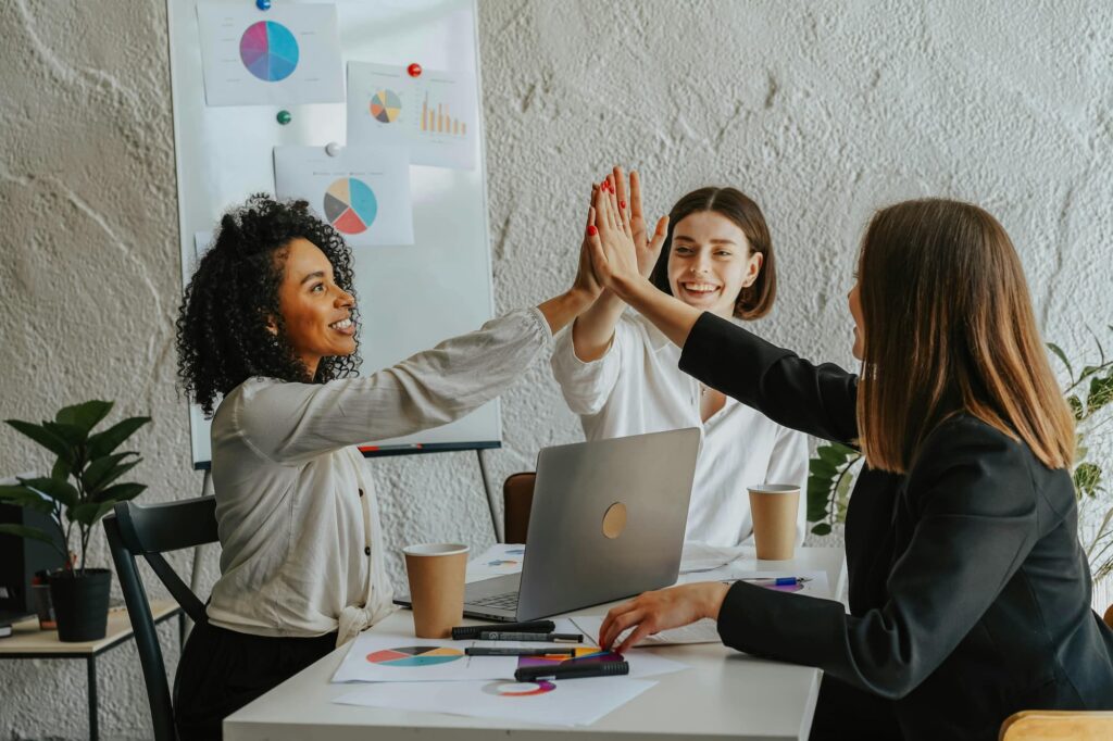 three-people-high-five-at-work-after-diversity-training