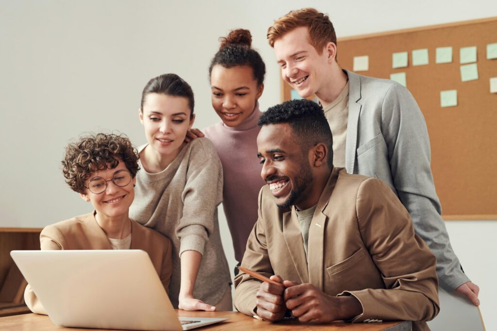 A group of employees reviewing DEI survey questions on a laptop, fostering an inclusive workplace discussion