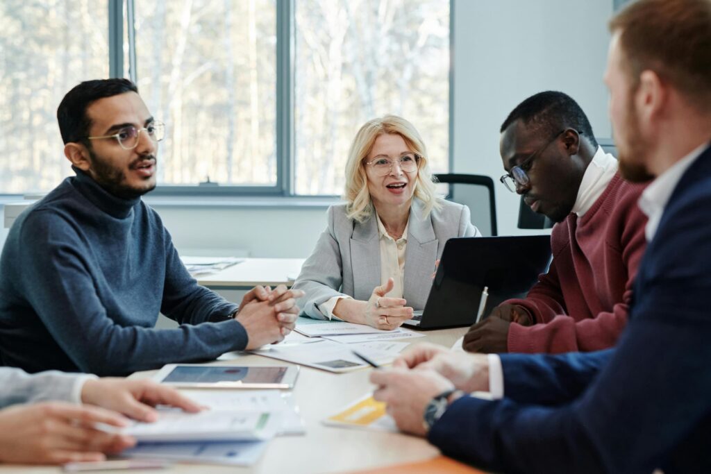 A group of colleagues meet in a conference room at work to discuss dei training