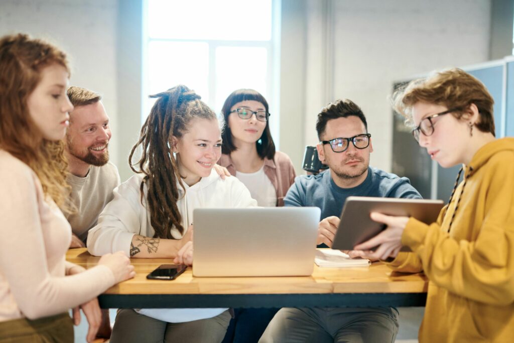 Young professionals in a modern office actively collaborating during a high-performance team meeting, illustrating effective management and teamwork.