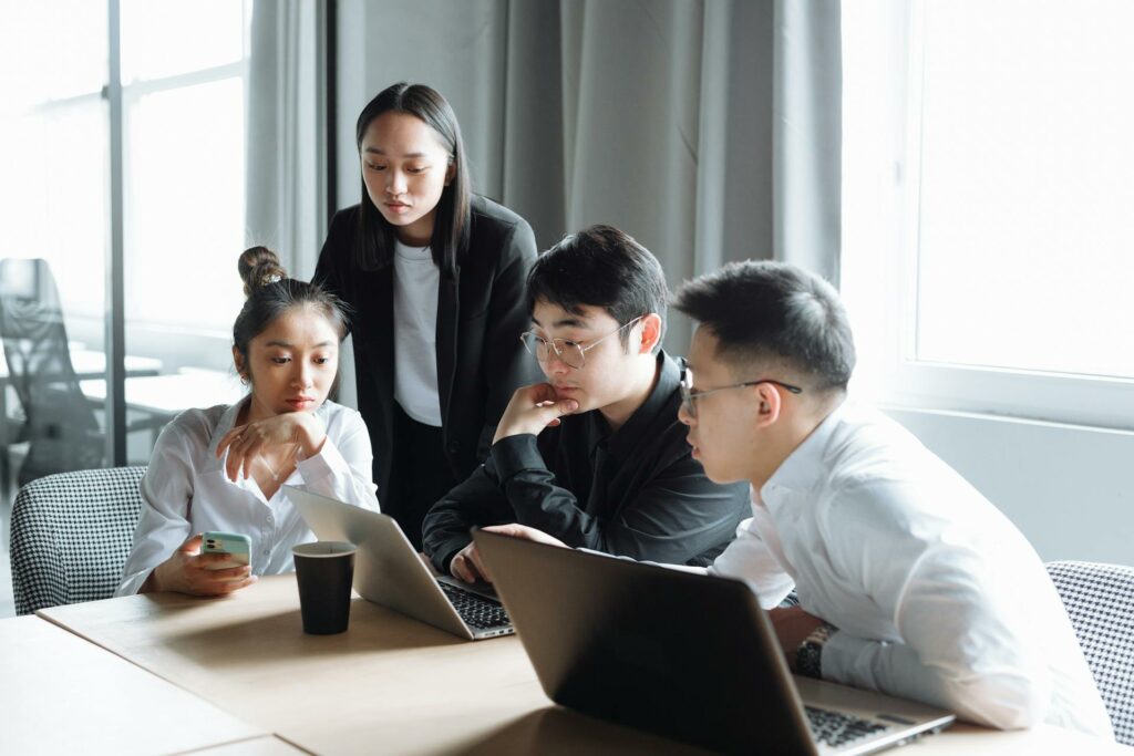 four coworkers brainstorming around a desk inside an office
